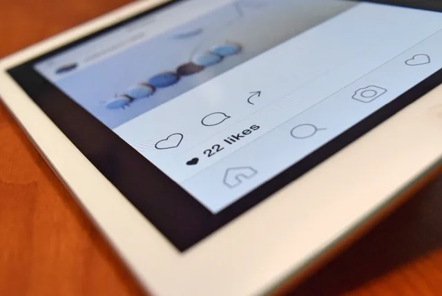 Photo of a tablet displaying a social media app interface with 22 likes, highlighting digital interaction. Sådan håndterer du kritik på sociale medier